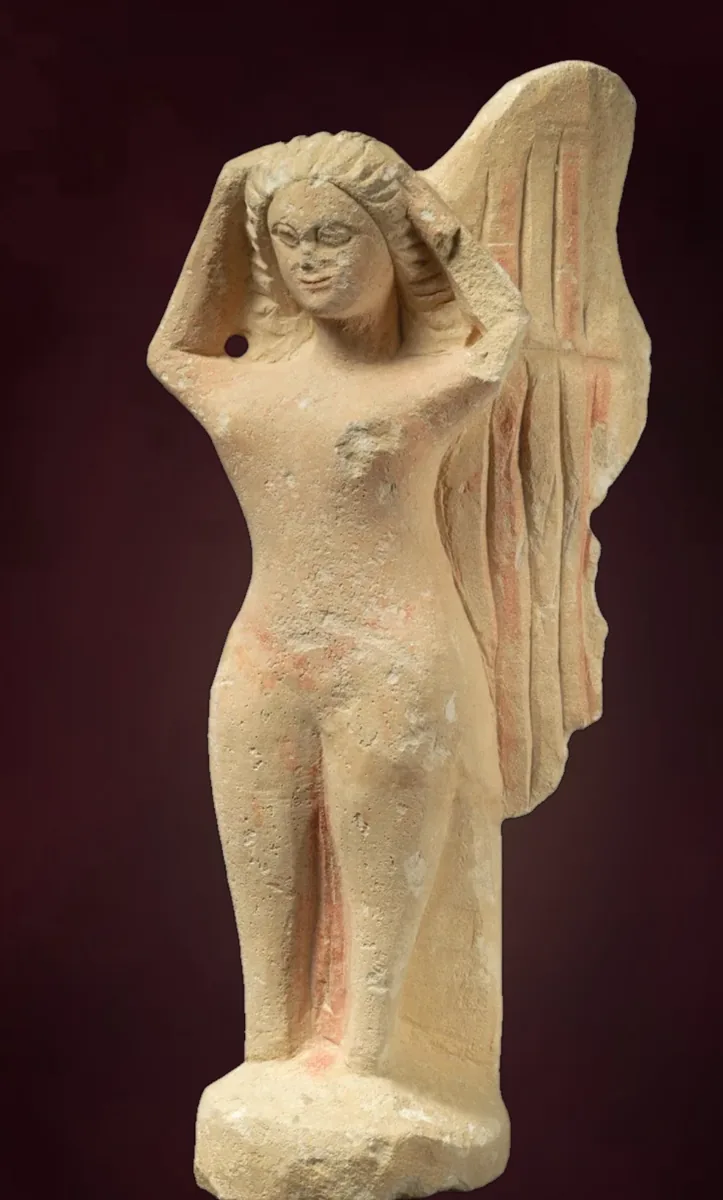 A small terracotta mourning siren with wings, hands raised to her head
